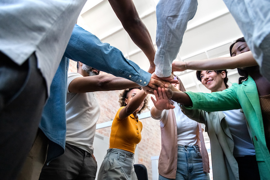 Multiracial coworkers join hands together in a circle. Multiracial coworkers join hands together in a circle. Business partners collaboration concept.